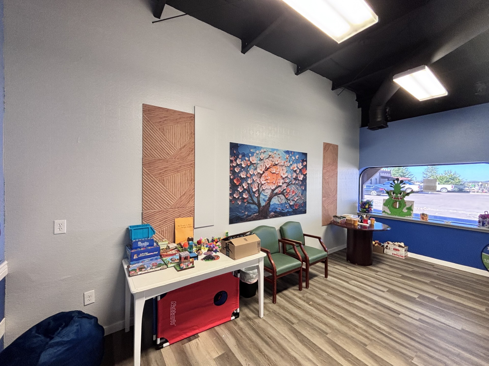 Child-friendly room with puppets, games, activity tables, and books.